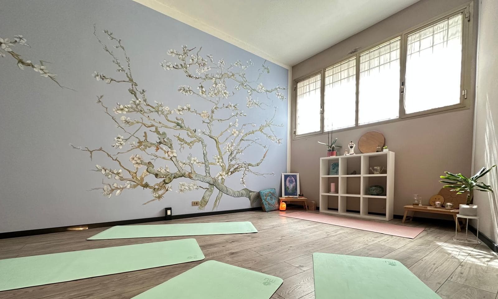 La sala dello studio Logos Yoga — parquet chiaro, luce naturale, atmosfera calda